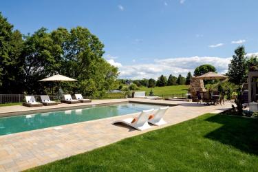 swimming pool with concrete paver decking and lounge chairs