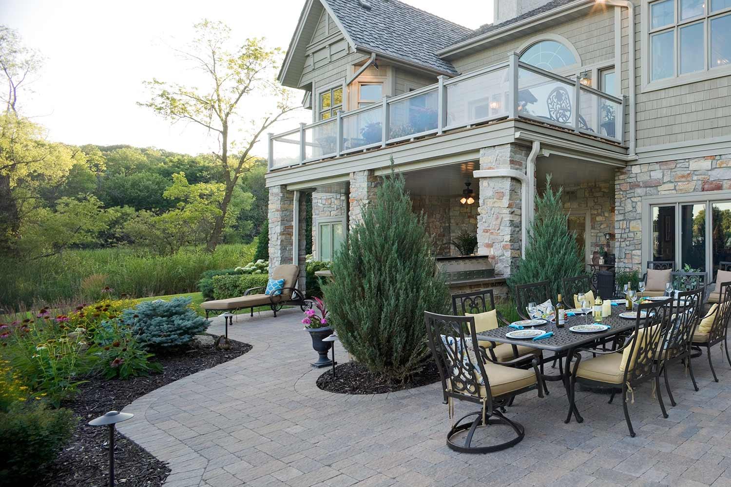 backyard landscape design incorporating plantings into the paver patio