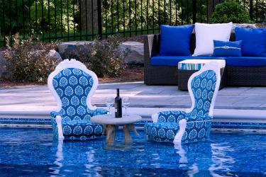 Two blue chairs with a floral leaf pattern place directly into the swimming pool.