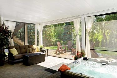 Under deck hot tub spa with pull down screens and curtains.