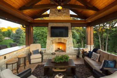 Outdoor Living Room with Stone Fireplace and Travertine Floor 