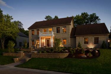 Night lighting highlights landscape and architectural elements of this formal front yard landscape design.