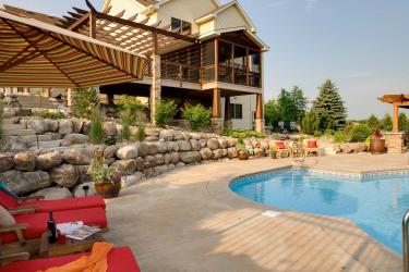 Resort style backyard with a boulder retaining wall and icy blue swimming pool.