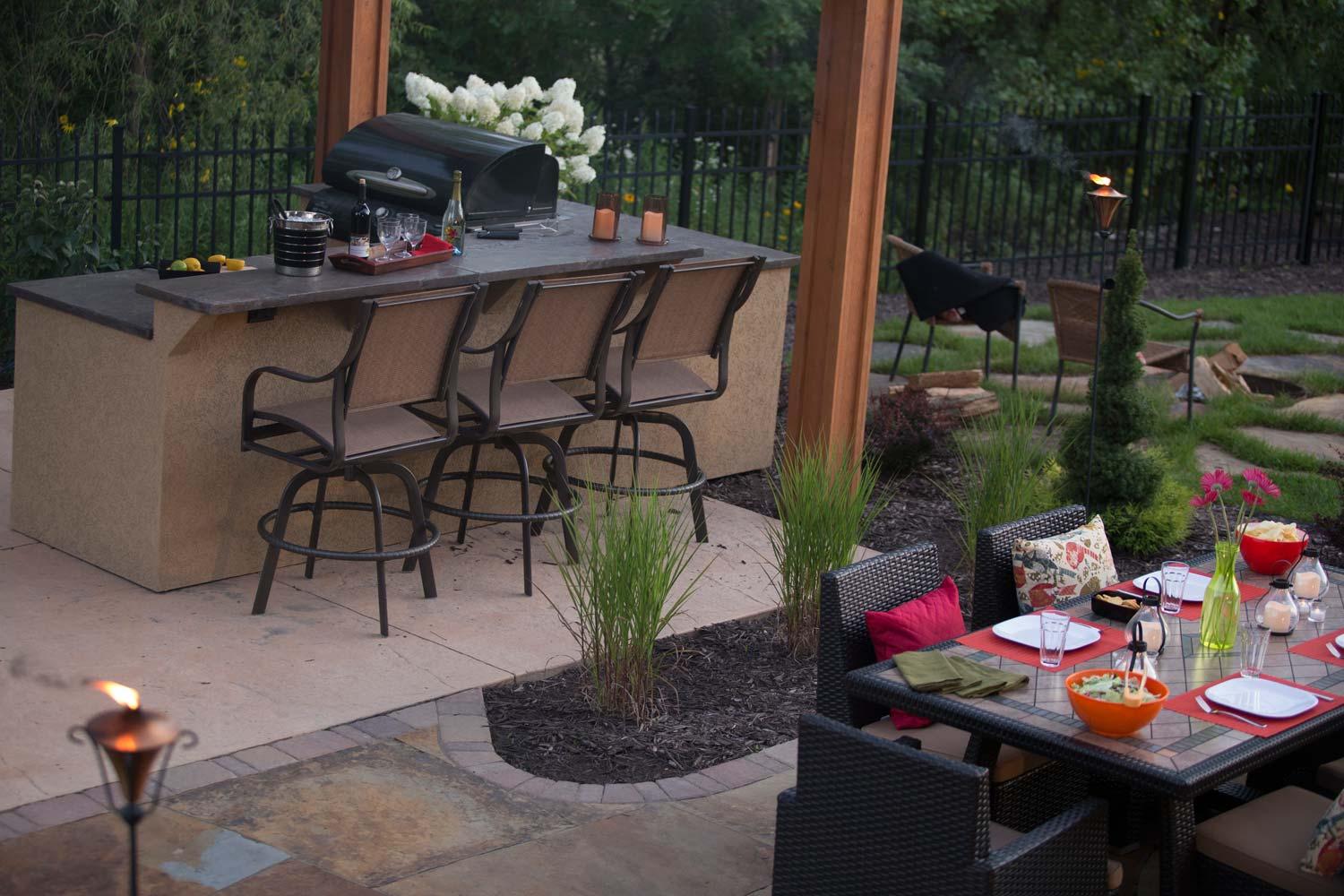 dining patio separated from outdoor pergola bar by tall grass plantings