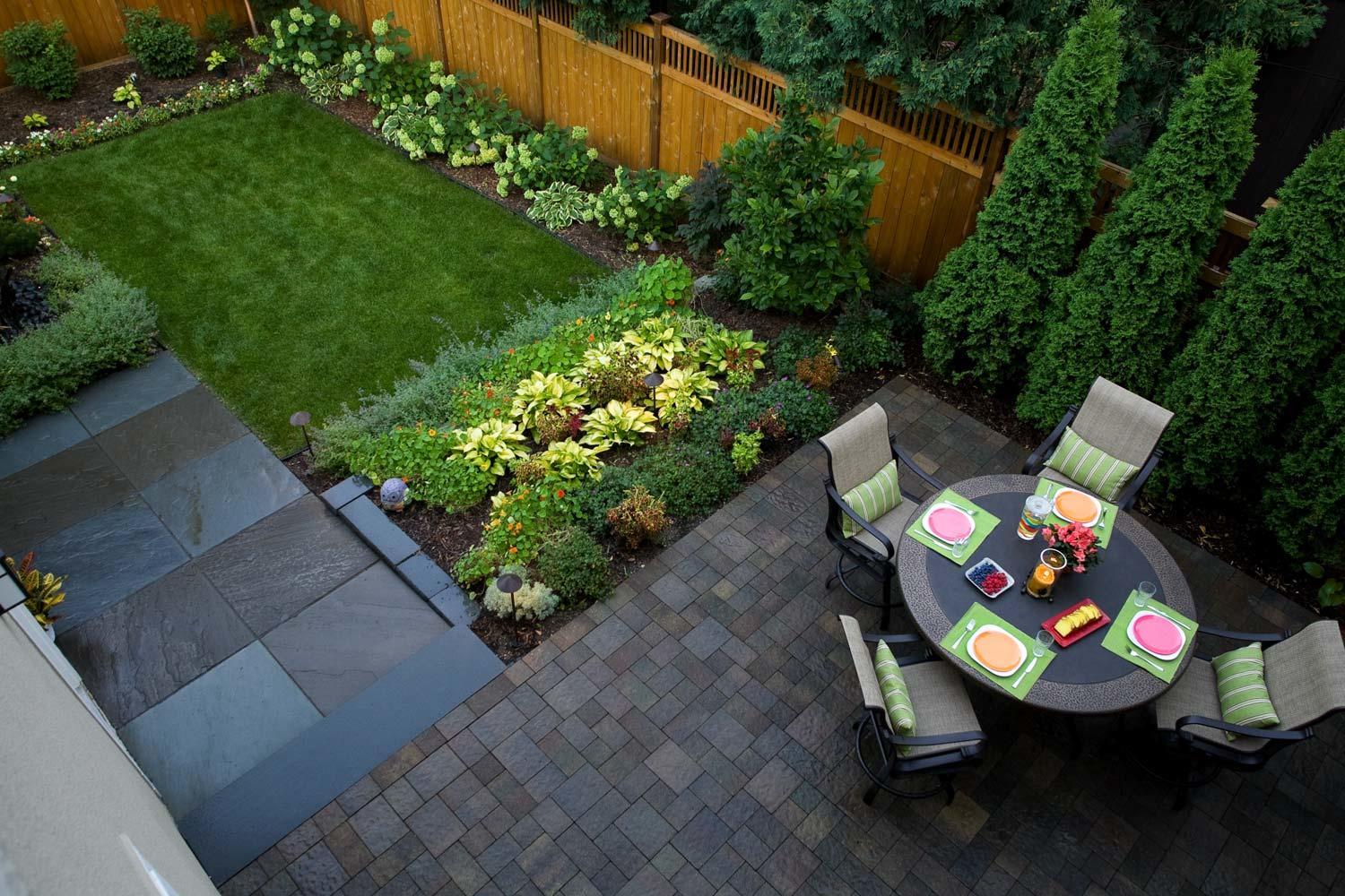 Small modern urban backyard with neatly divided walkways plantings and patios in Minneapolis Metro Area