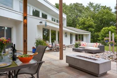 Expansive modern walk-out patio with dining area, fire table, and seating patio.