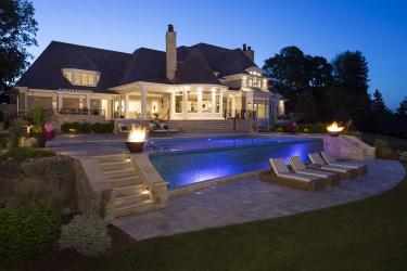 backyard swimming pool landscaping with fire features and night lighting