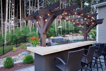 Outdoor bar with arching pergola and bauble lights