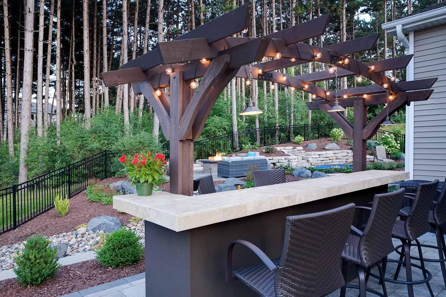 Outdoor bar with arching pergola and bauble lights