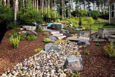 backyard without grass has a dry creek bed to help manage landscape drainage