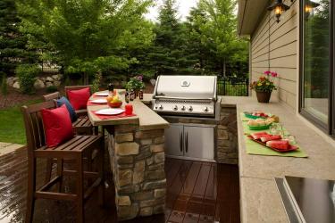 Outdoor kitchen with build in grill and two level bar counter
