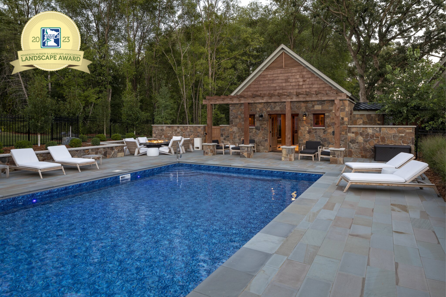 swimming pool with pool house surrounded by bluestone natural stone