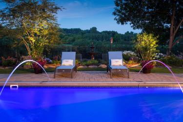 Backyard swimming pool with laminar jets and LED lighting