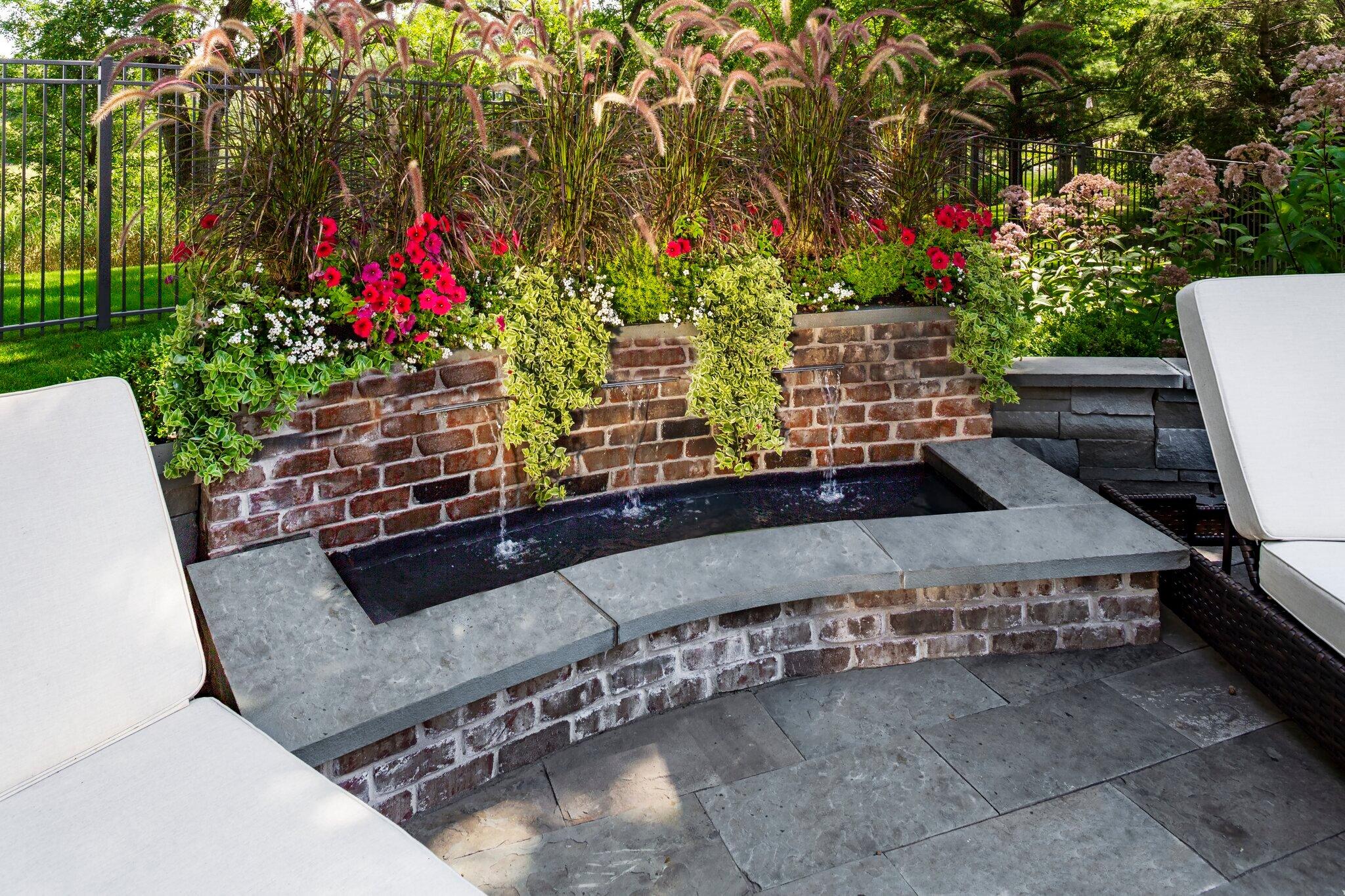 custom brick water feature with built in colorful planters