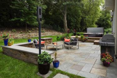 modern stone backyard patio with a stacked stone seat wall
