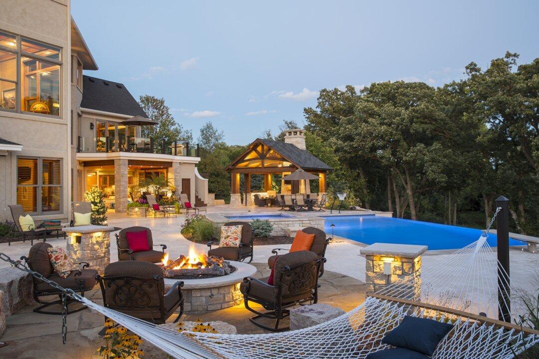 large backyard with swimming pool, outdoor living room, firepit and outdoor lighting