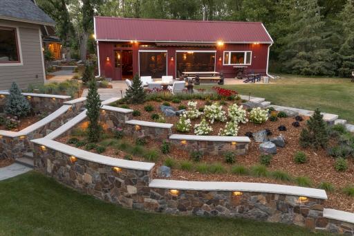 stone retaining walls with colorful perennials and a bluestone patio