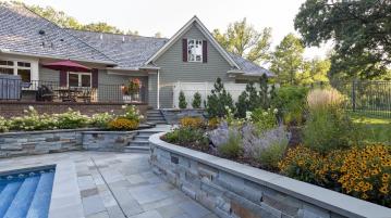 bluestone pool deck and retaining walls with abundant and colorful plantings