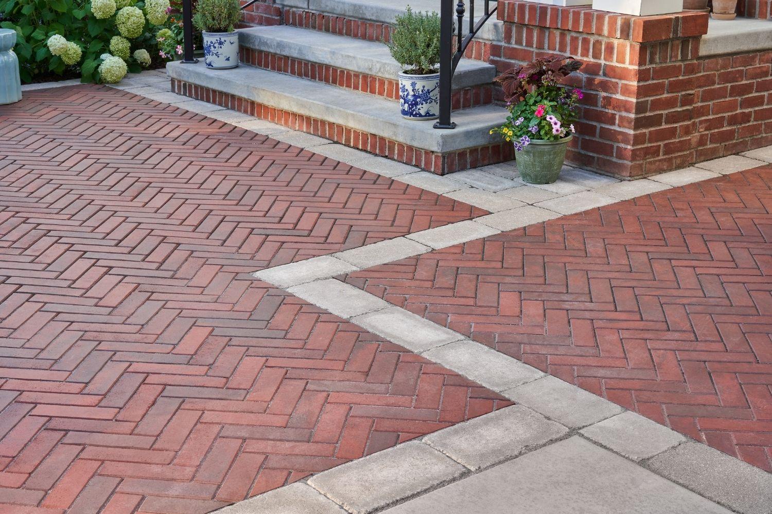 Brick front steps with clay paver patio in herringbone pattern concrete paver border. 