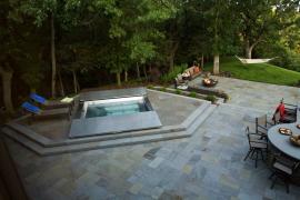 stainless steel hot tub surrounded by abluestone patio