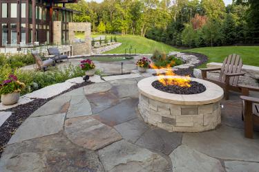 backyard landscape with a pool, outdoor kitchen, fire pit, and dining area.
