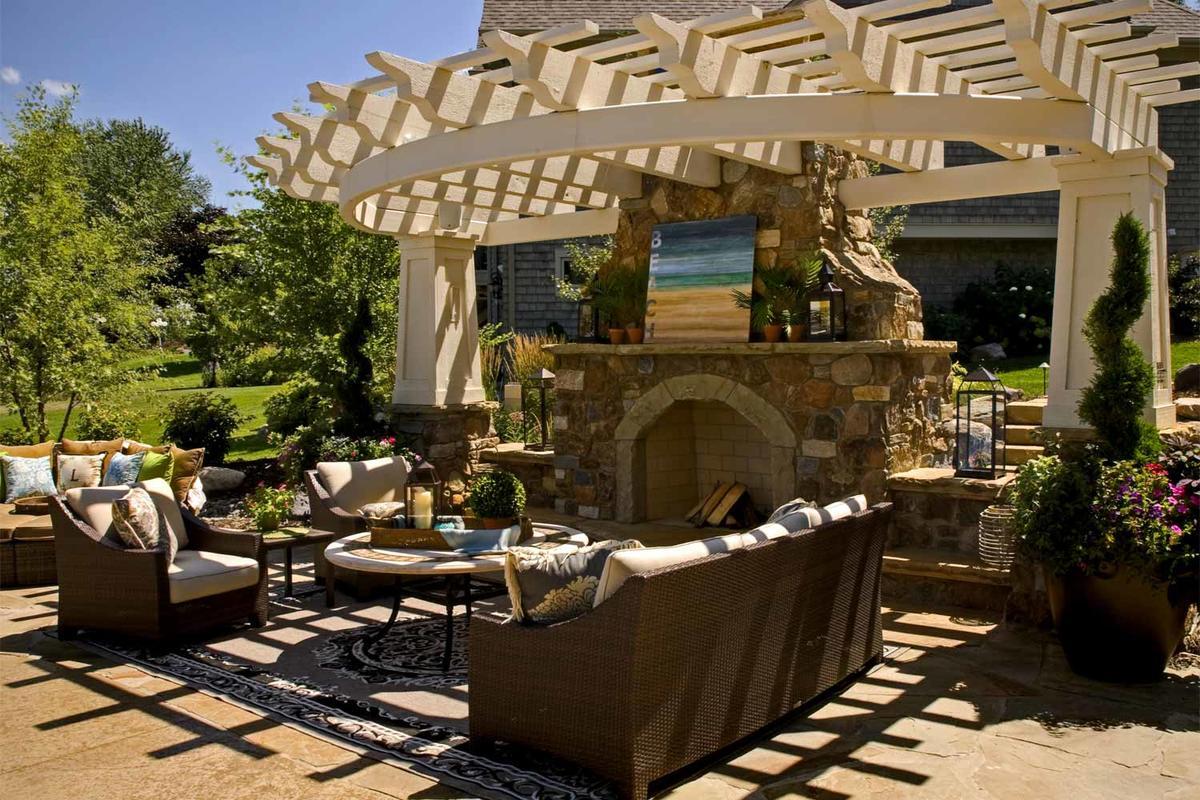 Luxury outdoor living room with custom fireplace with cantilevered pergola 