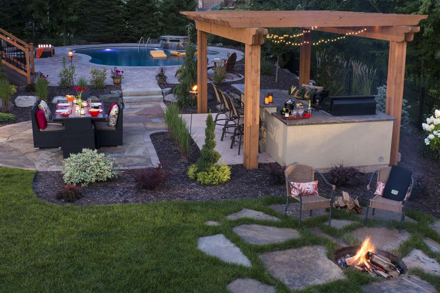 dining patio, fire pit, and pergola over outdoor kitchen and bar