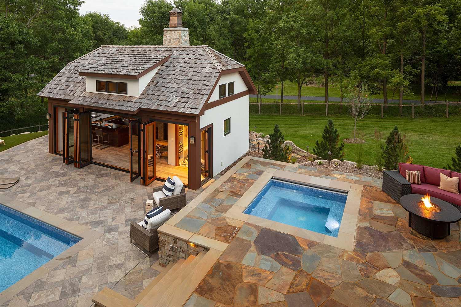 Pool house, hot tub, and natural stone patio and pool deck.