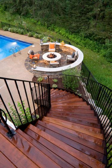 Curving staircase leads to a fire patio