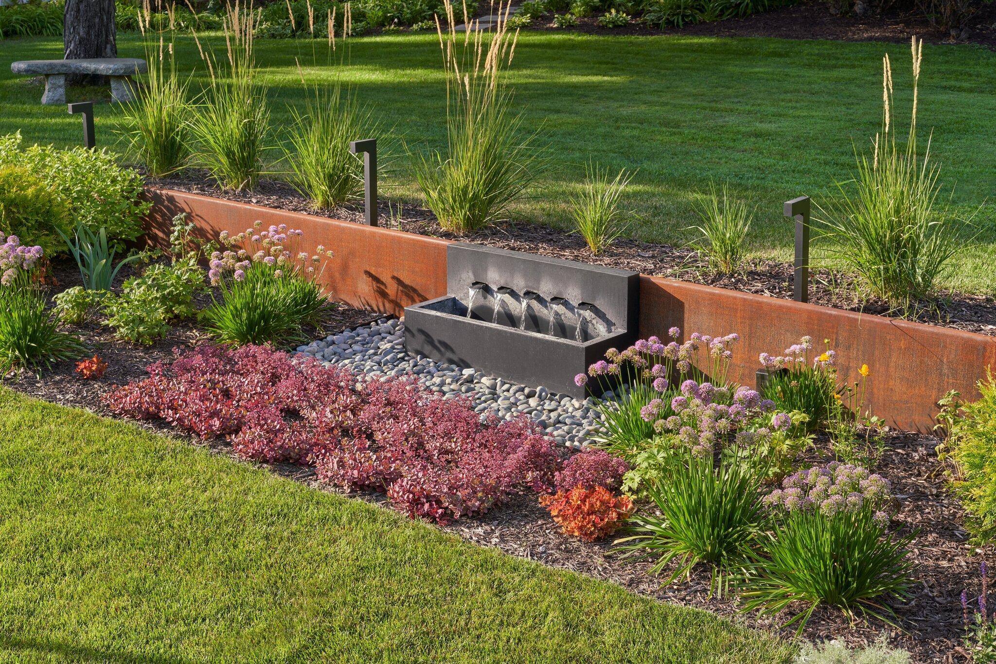 corten steel walls and modern water feature in garden bed