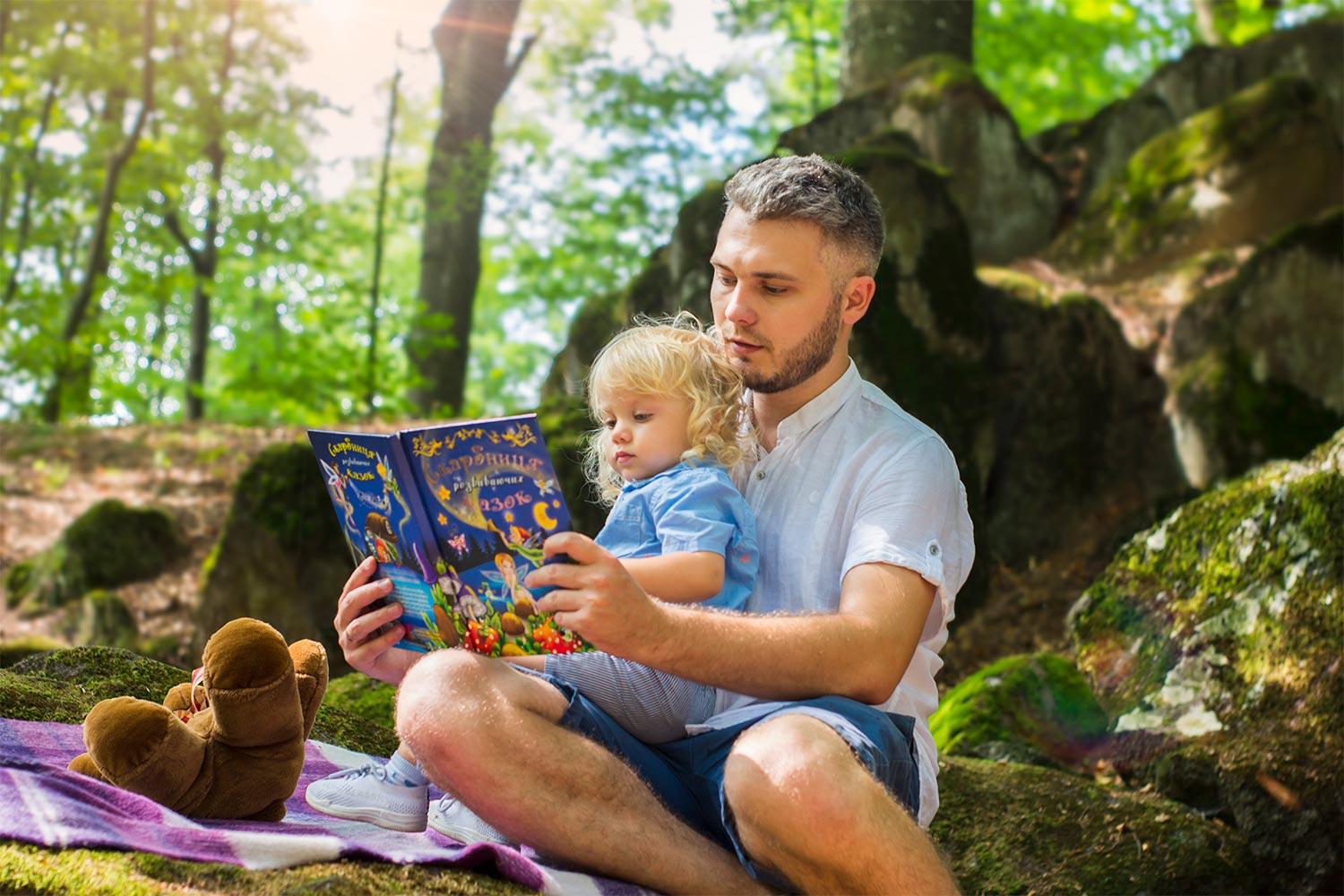 photo of man and child reading a book outside