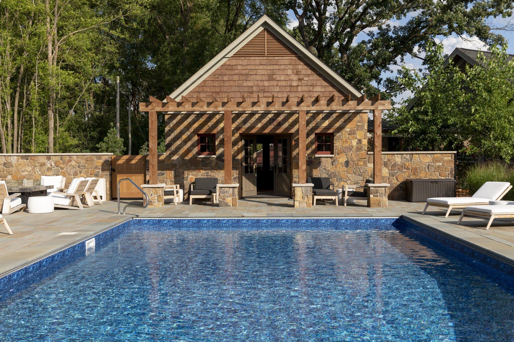 masonry pool house with pergola and bluestone pool decking
