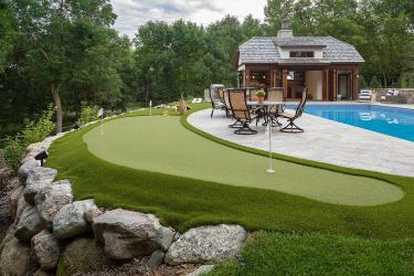 Poolside putting green and outdoor game space.