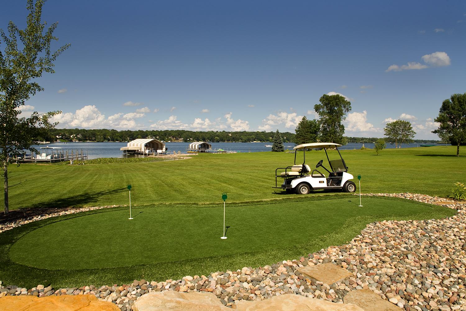 backyard putting green with golf cart and lake view
