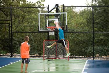 Asphalt backyard surface with an adjustable basketball hoop