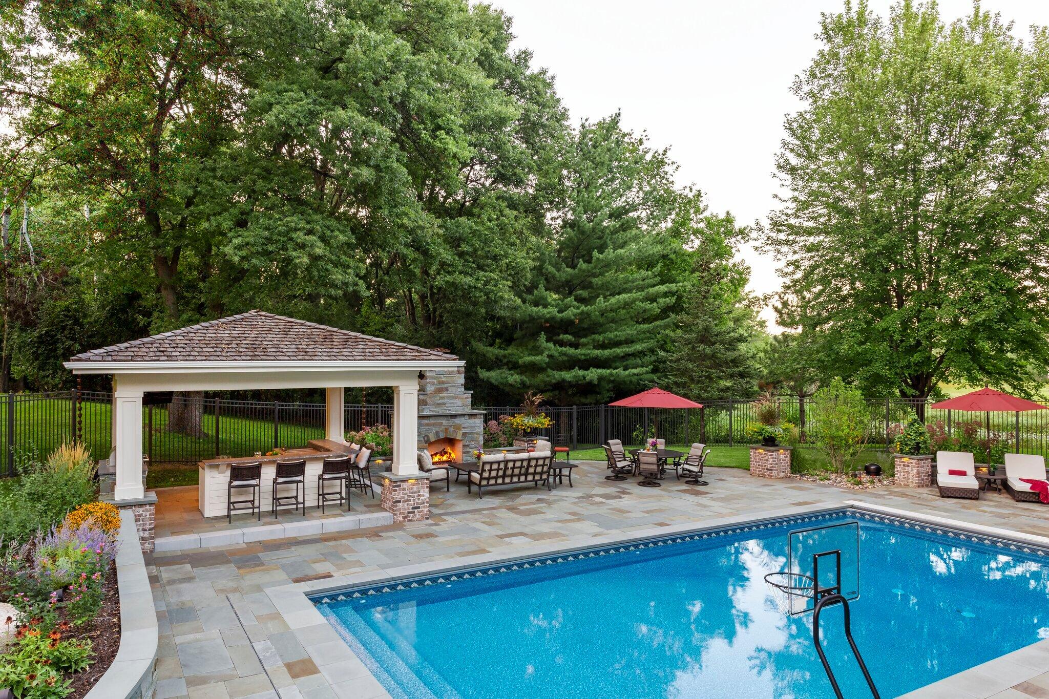 backyard featuring a swimming pool, fireplace and covered outdoor kitchen