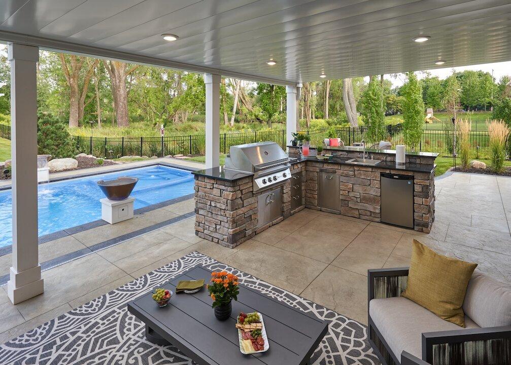 Under deck patio with outdoor kitchen and seating area