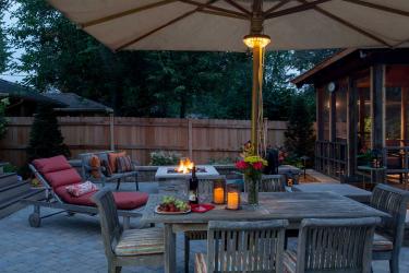 small backyard with paver patio, screen porch, and square fire table