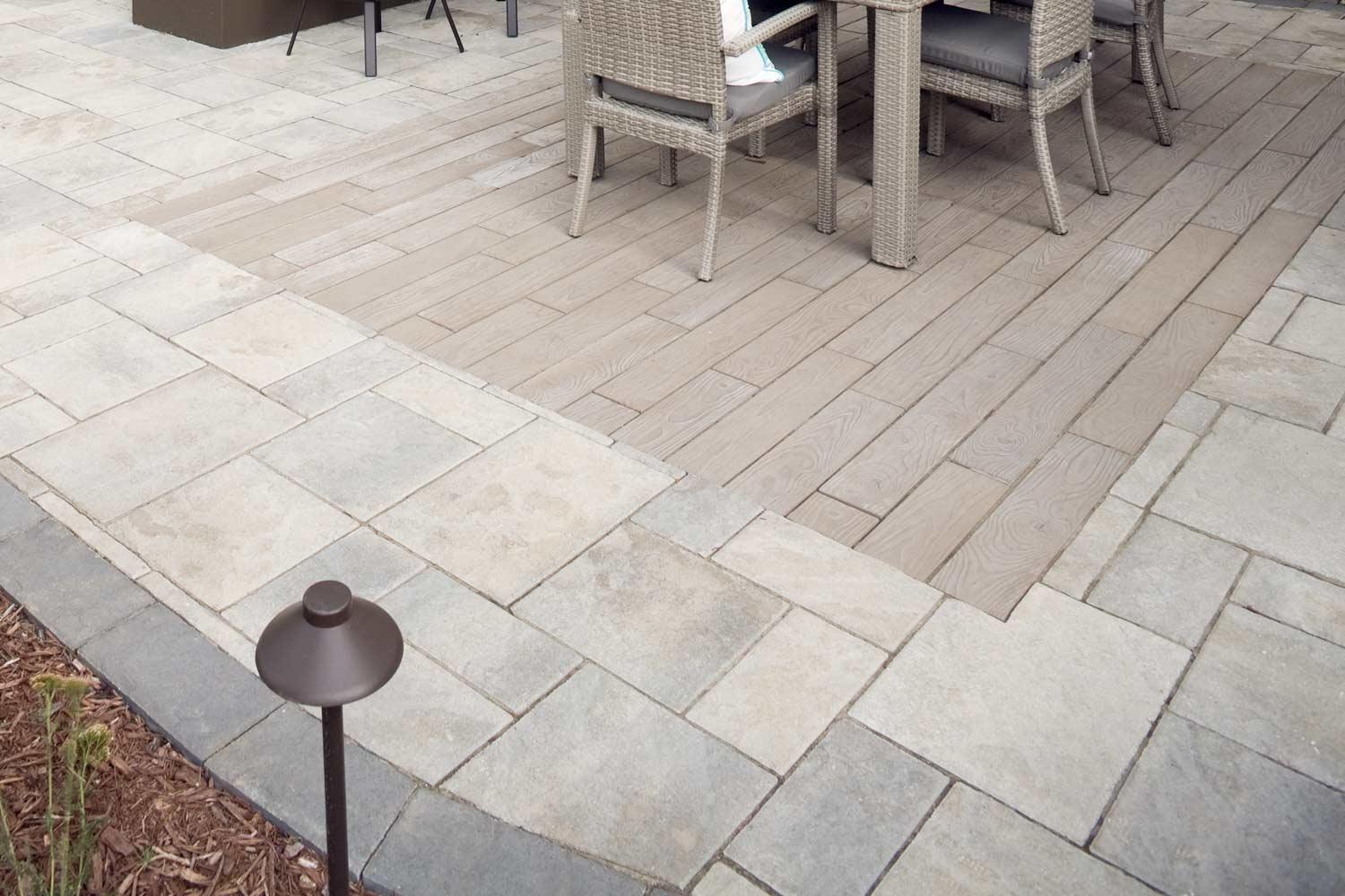 Paver patio designed with inlaid contrasting wood-look pavers.